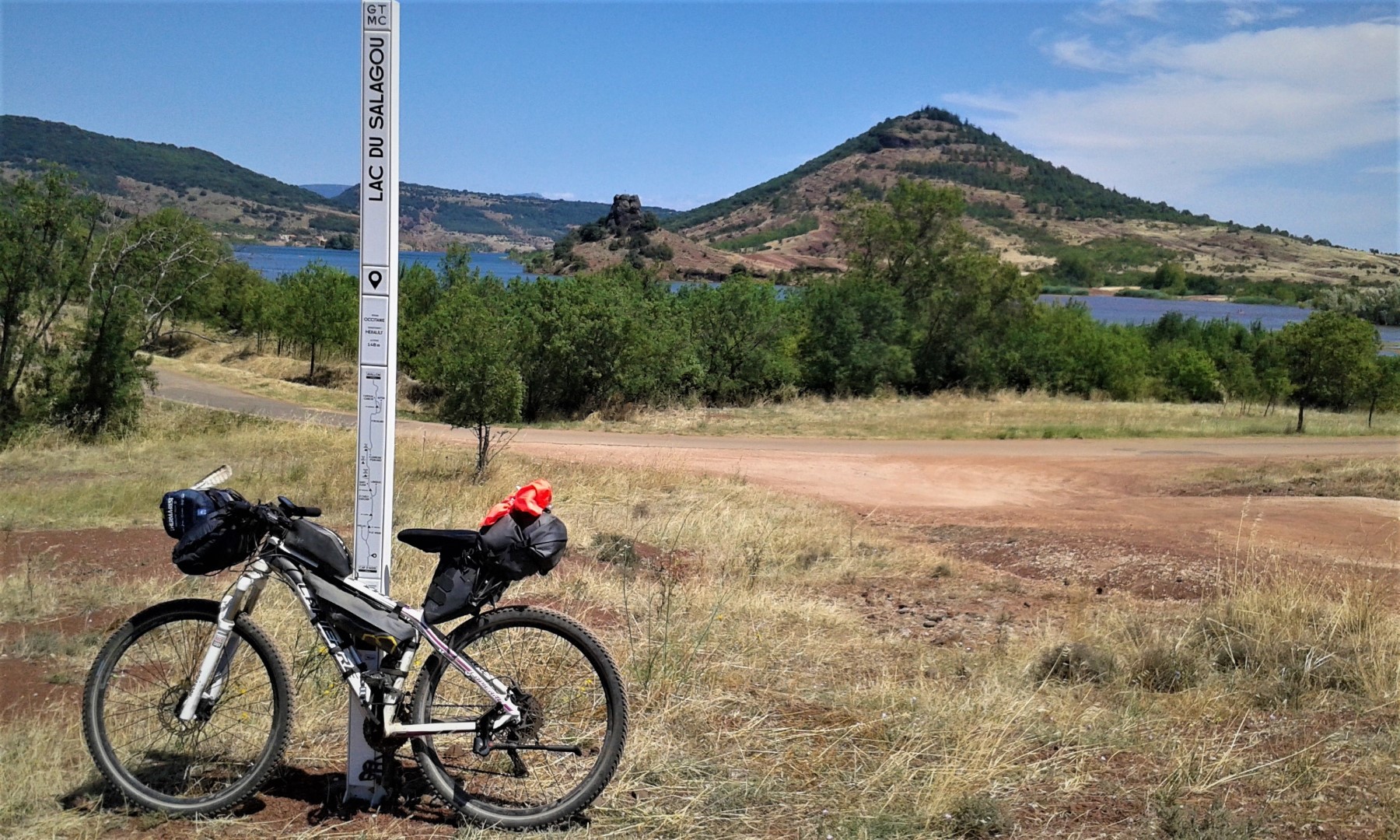 Vélo devant le totem du Lac du Salagou